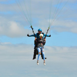 approche et atterrissage d'un pilote et son passager  en parapente