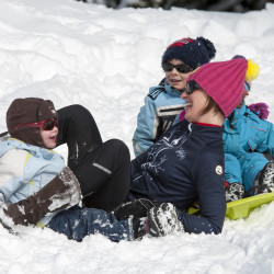 Famille jouant dans la neige lors d'une sortie en raquettes